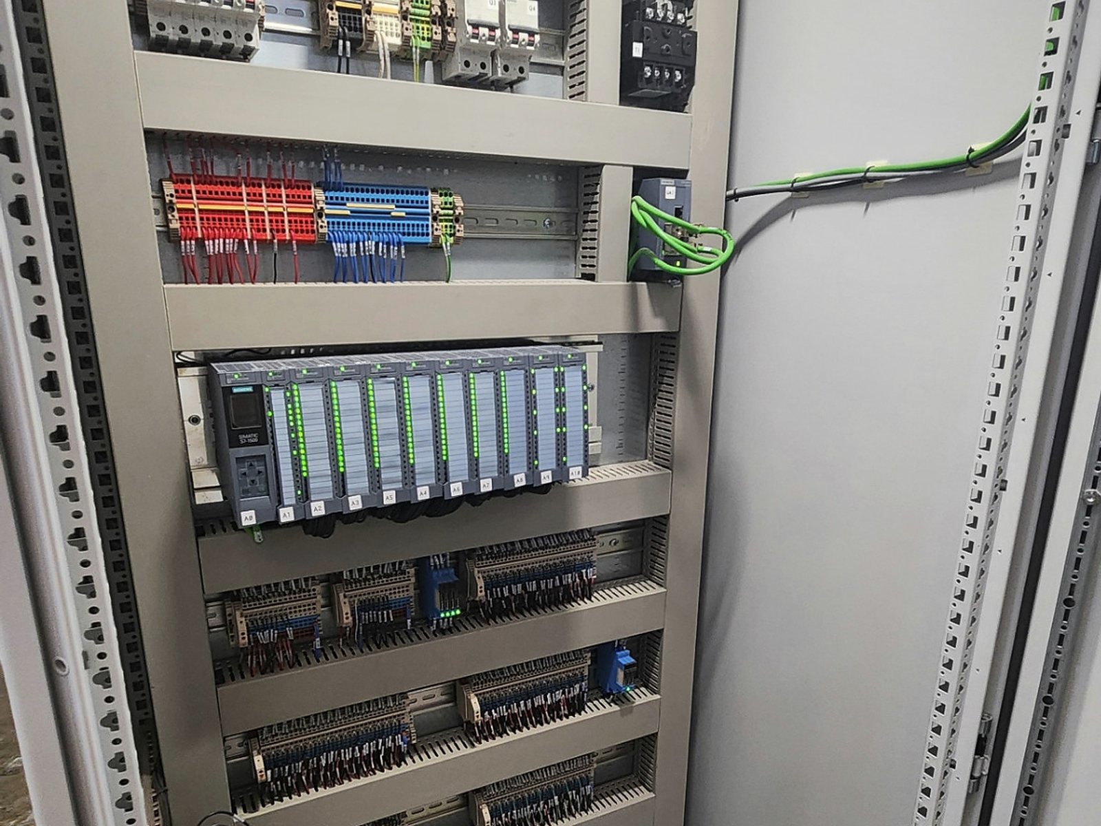 Tablero de automatización con fuente, PLC, módulos de entradas y salidas y borneras.